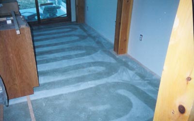 Pre-tile view of floor with water pipes in subfloor